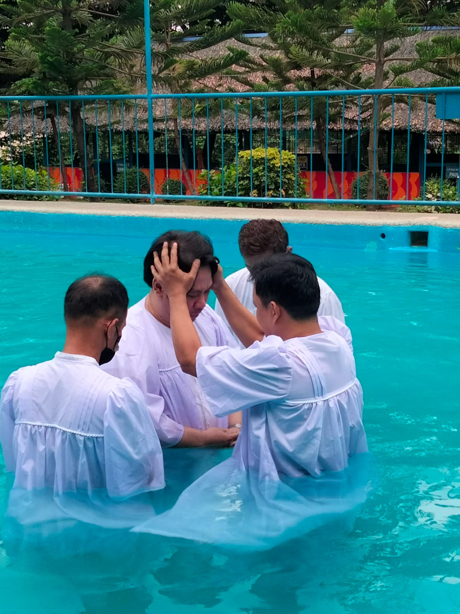 Wide view of the baptism pool area with participants in white robes
